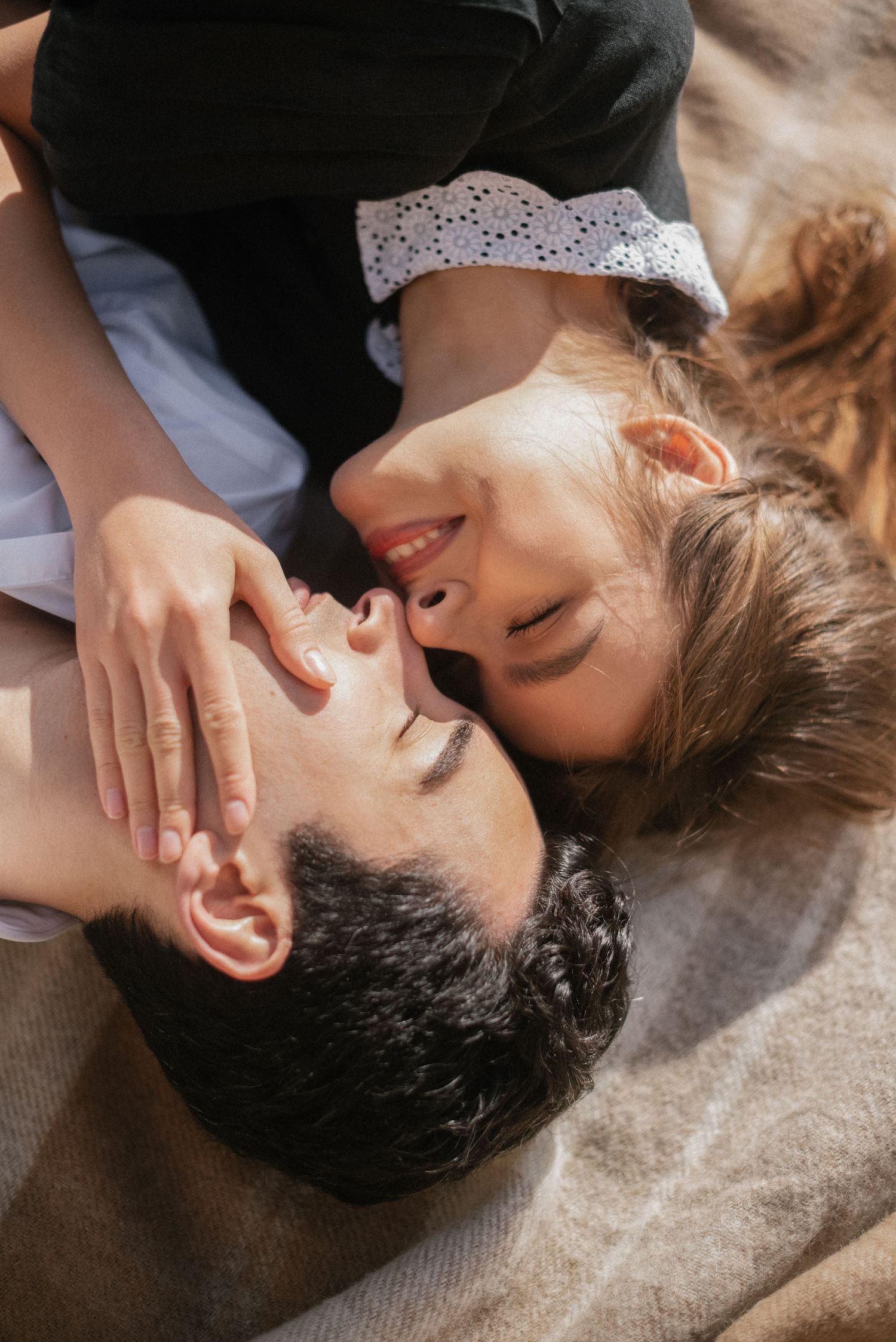 Intimate overhead portrait of couple lying close together.