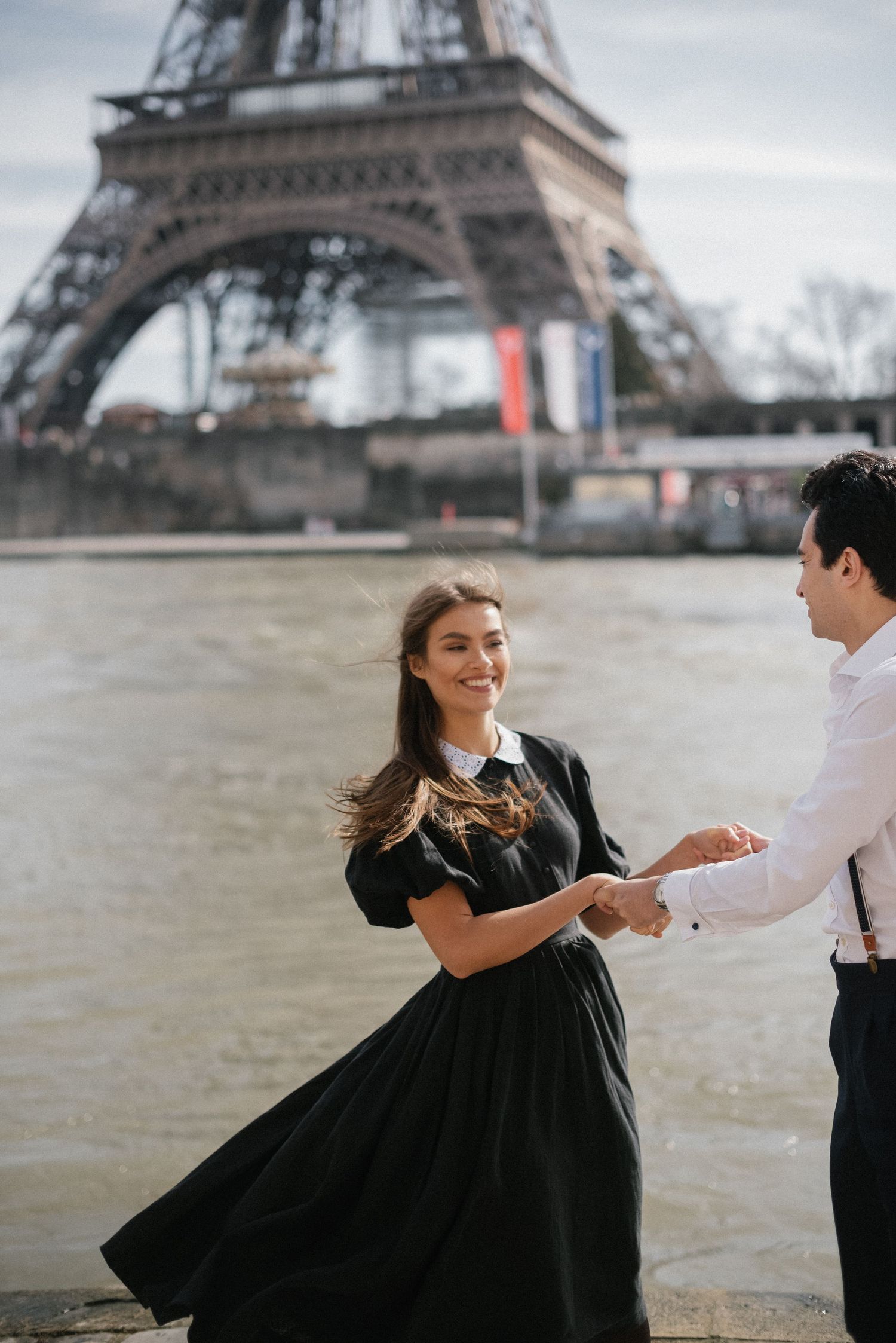 A couple dancing together against the backdrop of the Eiffel Tower.