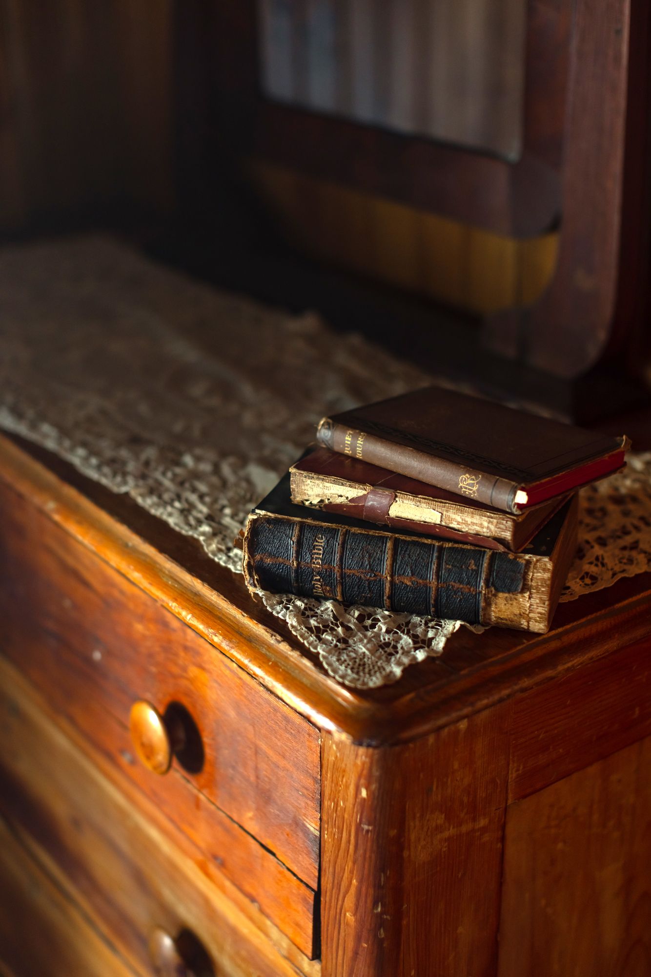 Antique Bibles rest on vintage lace on a weathered oak dresser at Saltonstall Farm in Stratham, New Hampshire. New Hampshire photographer