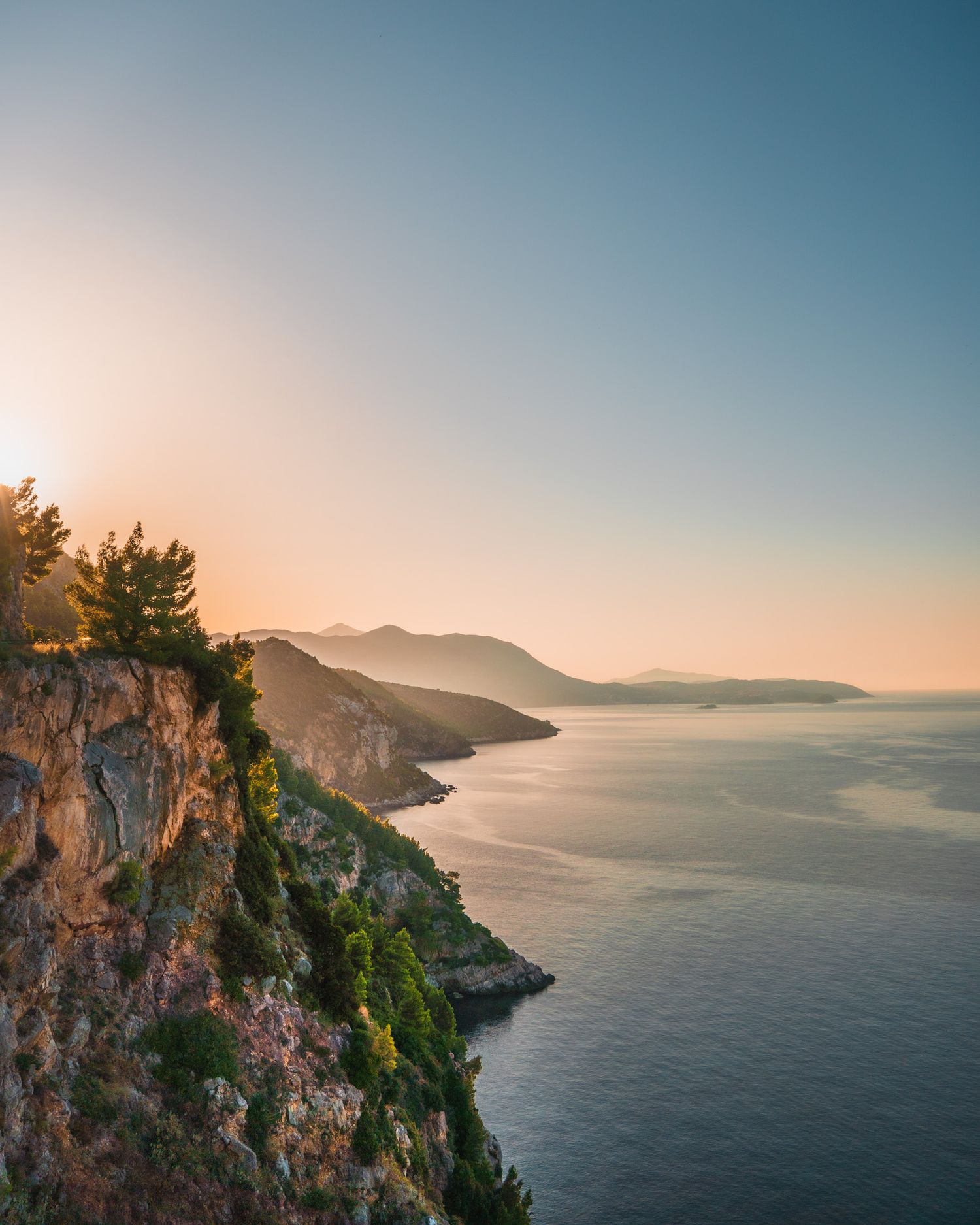 travel photo of croatian sunrise along an abandoned cliffside road with deep cliffs leading to a stunning morning ionian sea