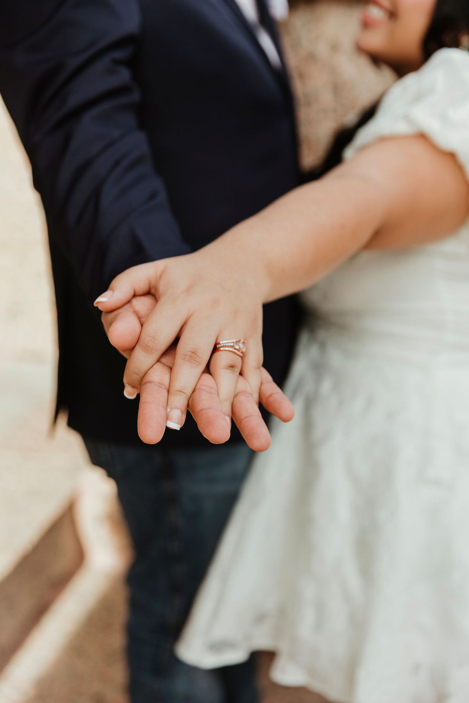 Close-up of interlocked hands showing wedding rings symbolizing marriage and commitment.