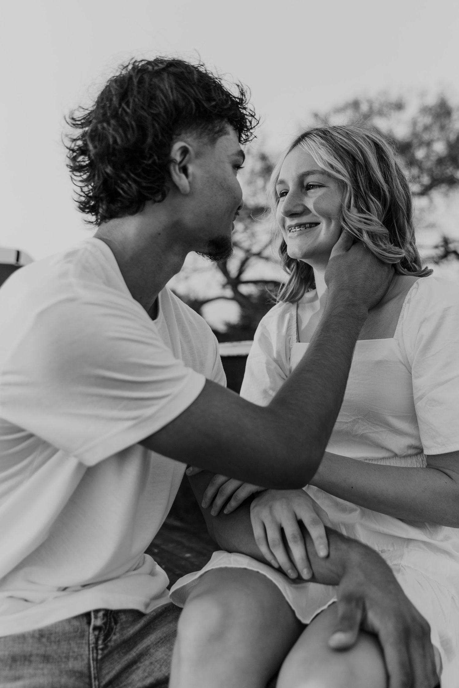 A romantic black and white photo series showing an intimate couple in white shirts sharing tender moments together.