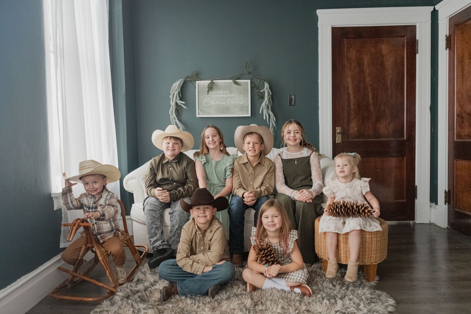 Family Christmas portrait session in room with blue walls and hardwood floors.