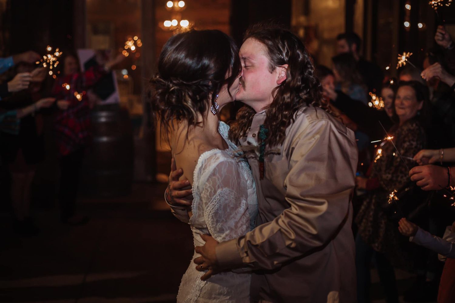 Couple sharing romantic moment under evening lights at wedding celebration.