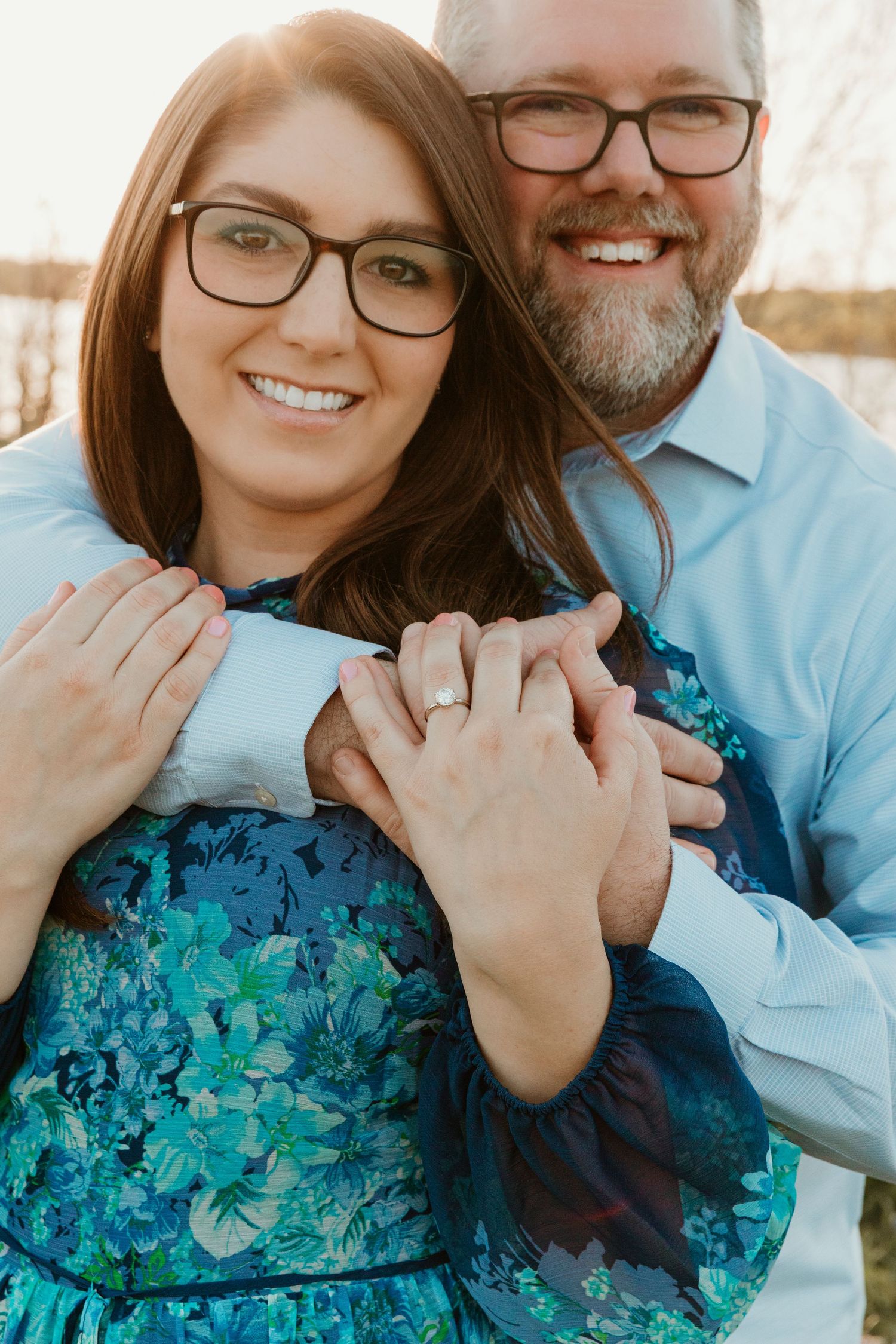 Engagement photos showing couple embracing in turquoise floral dress and light blue shirt.