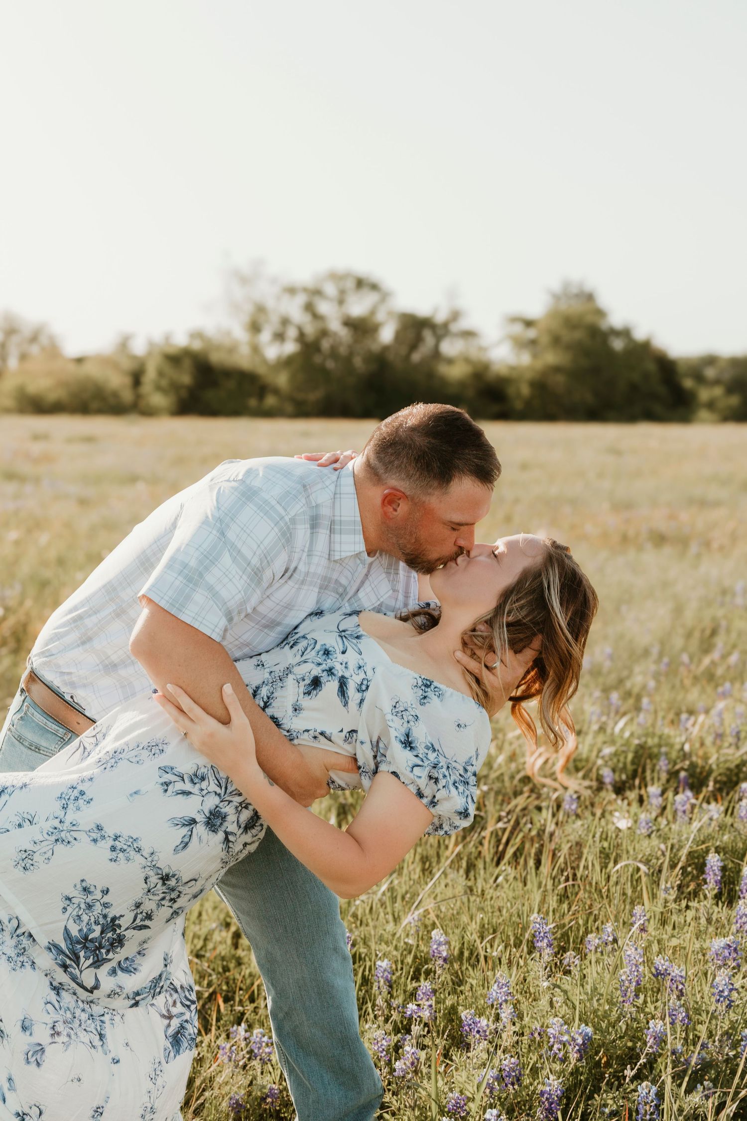 Intimate family moment captured in flowering meadow during golden hour photo session.