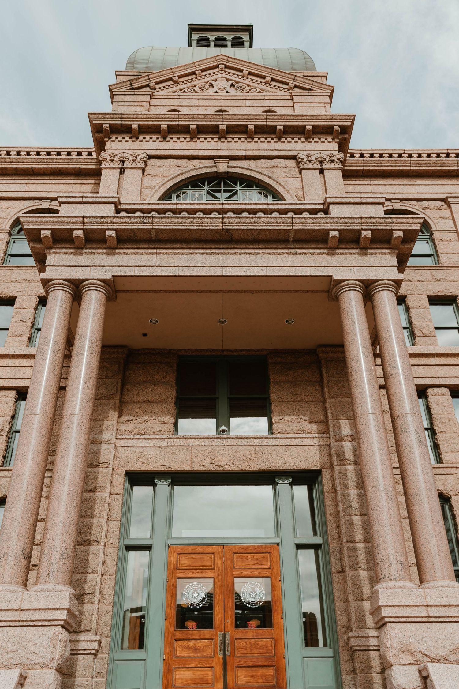 Close-up views of an ornate neoclassical building facade with columns and decorative stonework details.