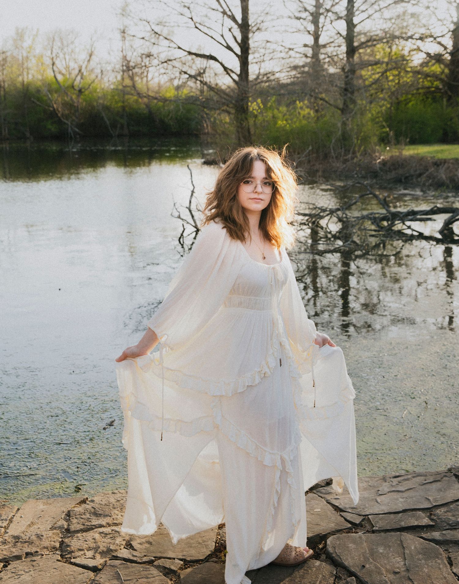 An ethereal white dress flowing in the breeze beside a serene lake.