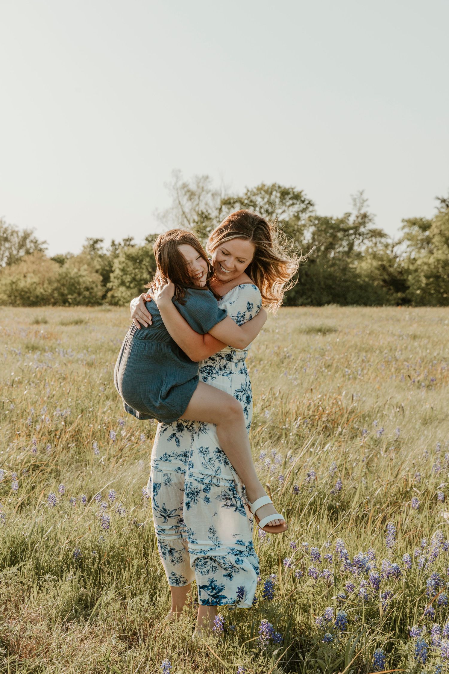 Joyful moment between family members playing in a golden field with wildflowers.