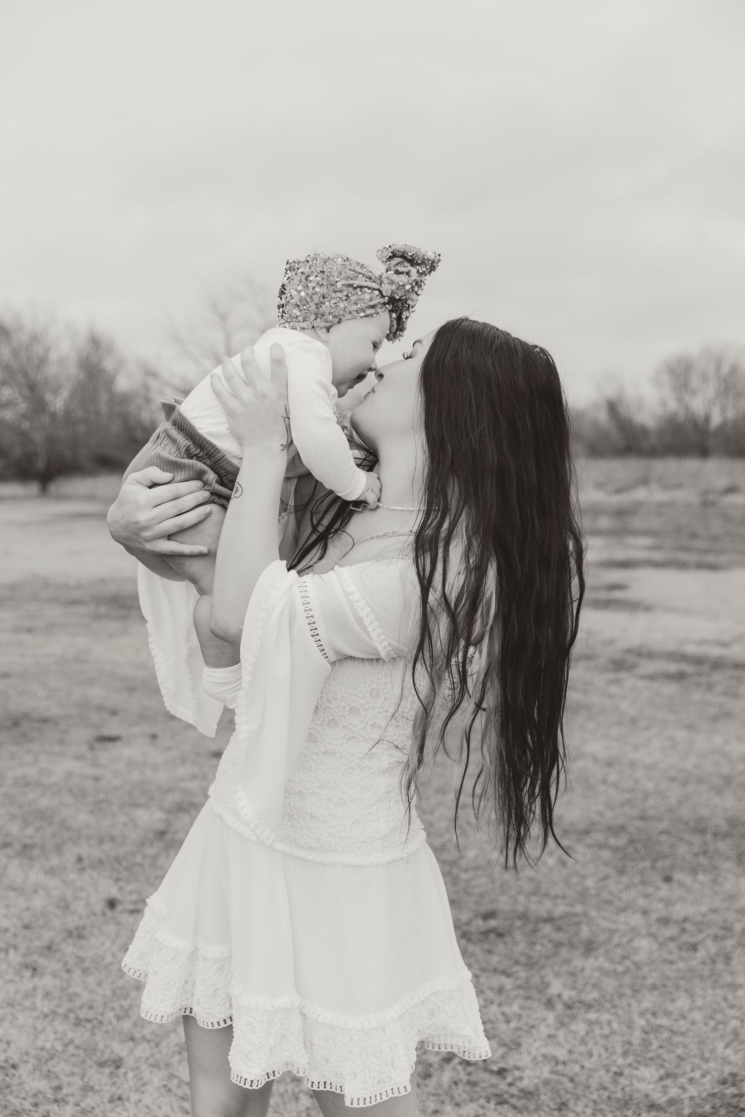 Black and white portrait of joyful moment in white dress outdoors.