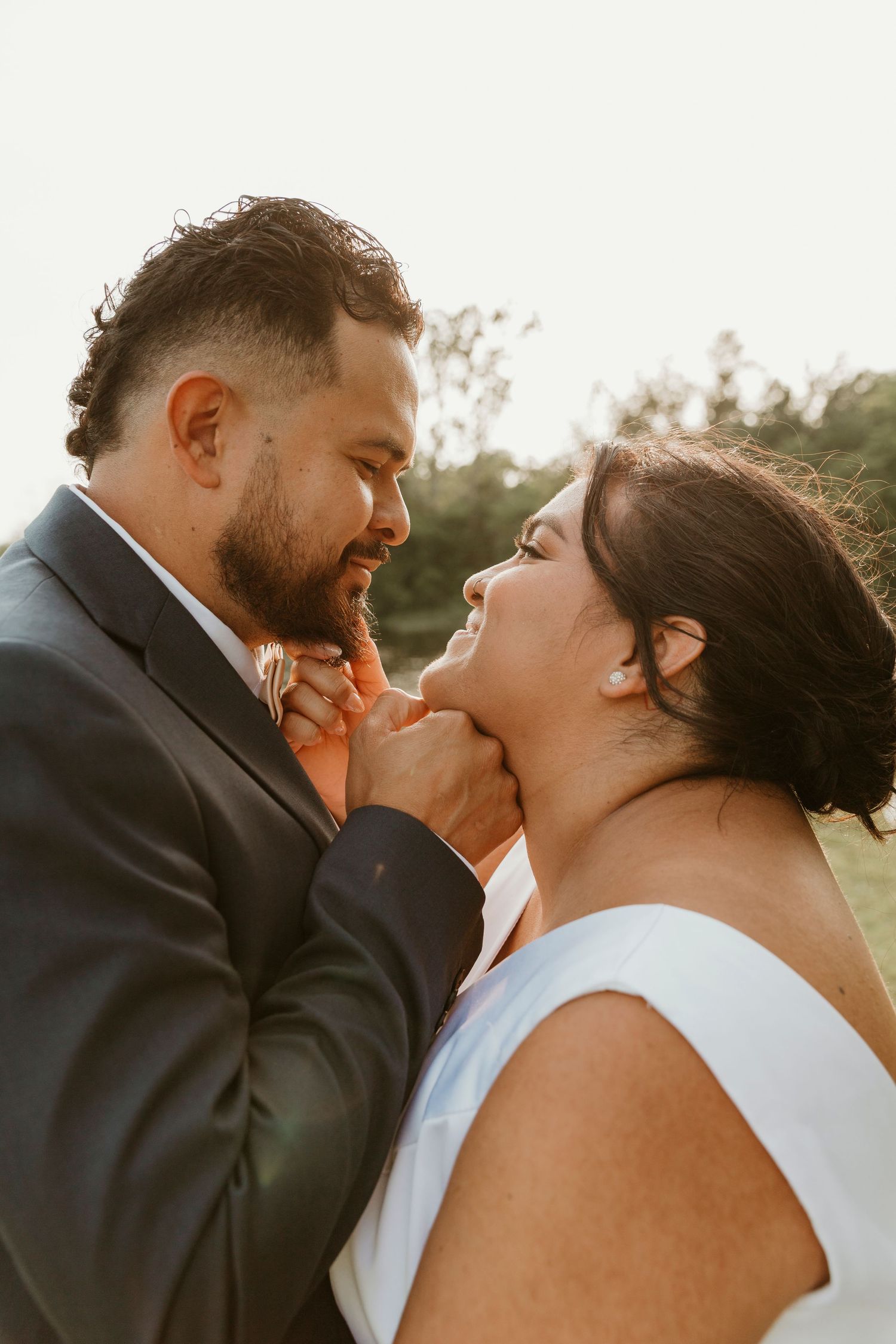 Golden hour wedding portrait capturing intimate connection between newlyweds.