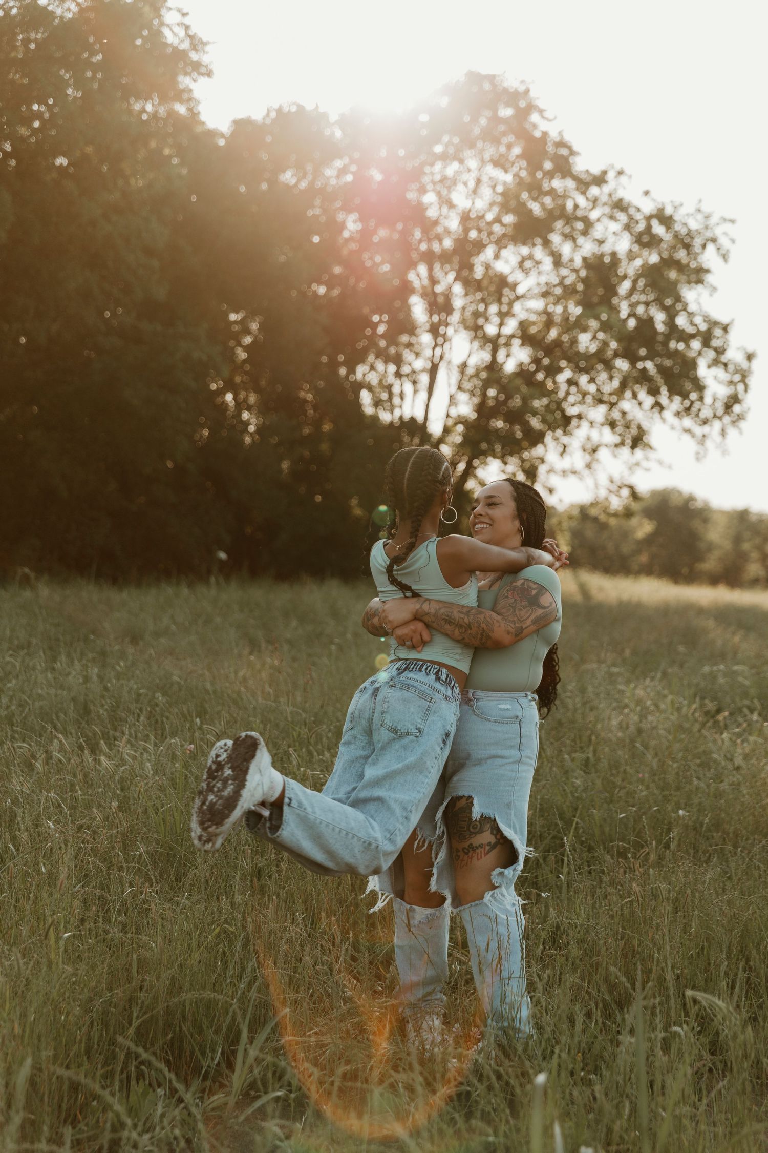 dancing and embracing playfully in a sunlit meadow at golden hour.