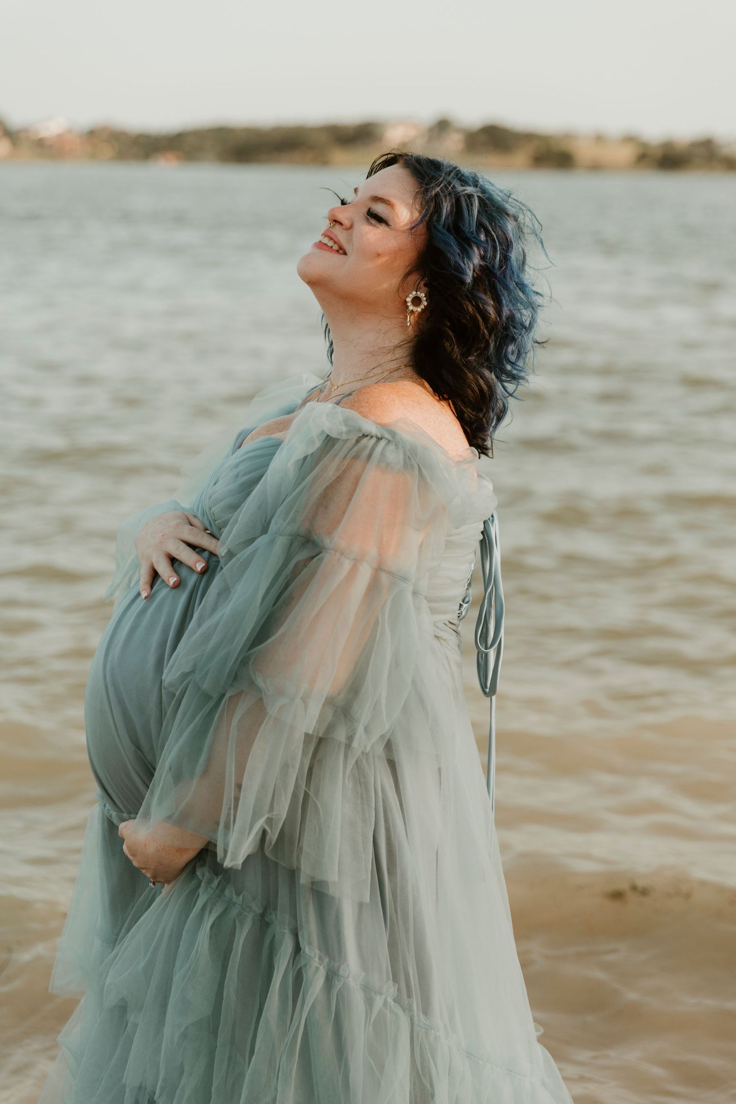 An ethereal maternity photoshoot featuring a flowing mint green dress by the ocean.