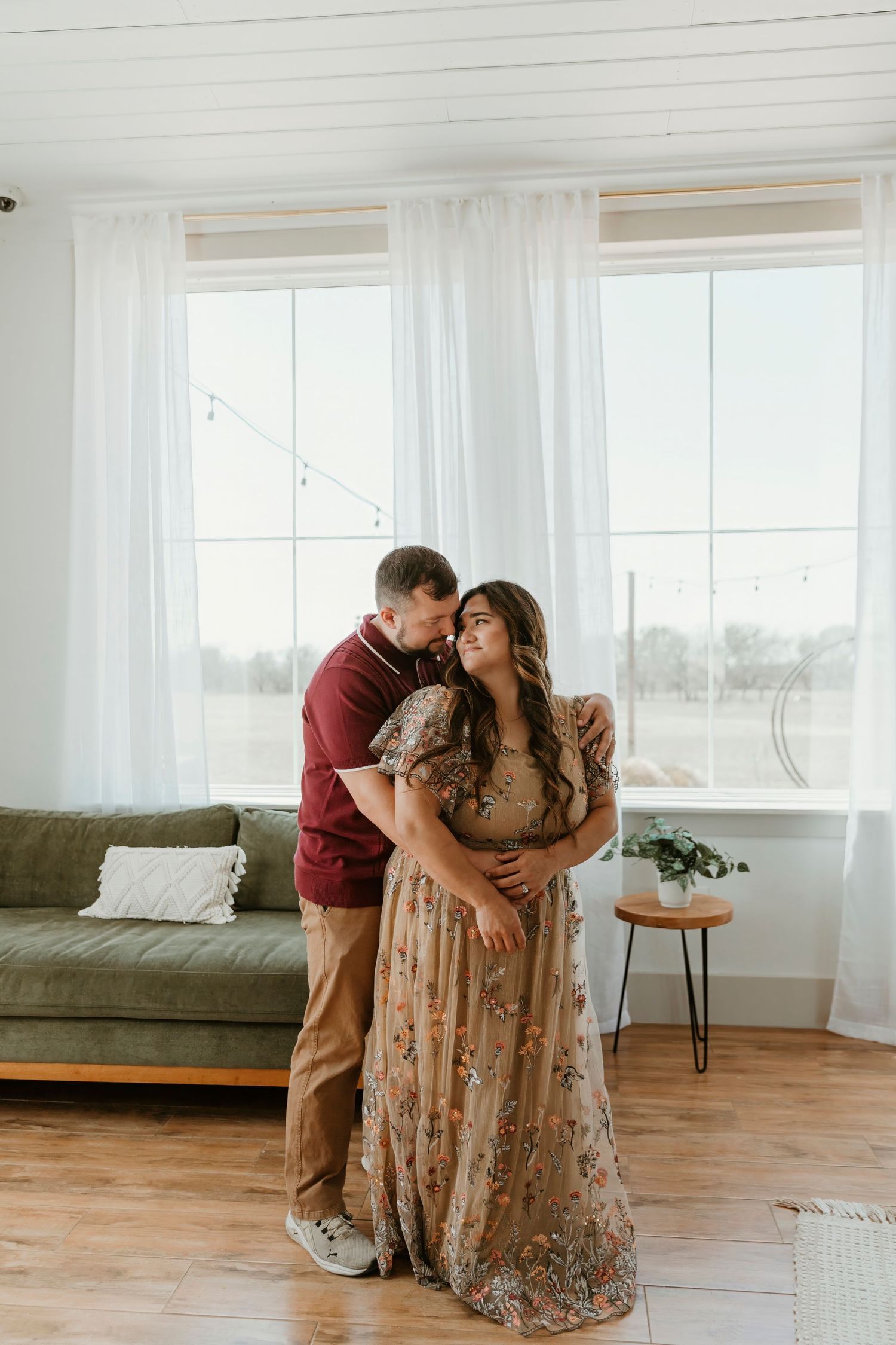 Family sharing tender moments in a bright modern living room with hardwood floors and white curtains.