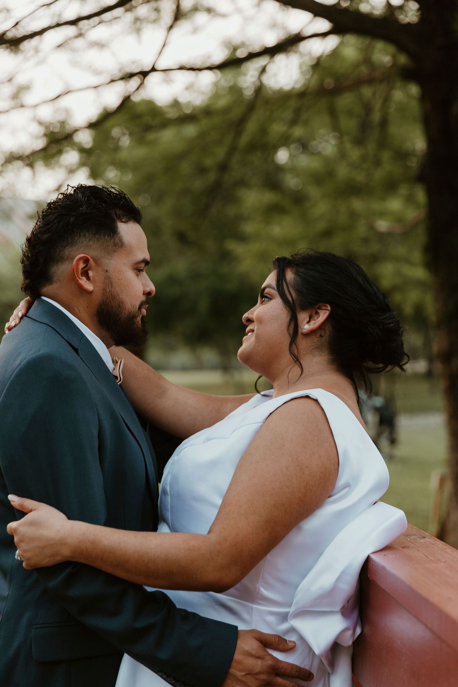 Romantic couple embracing during outdoor wedding photoshoot.