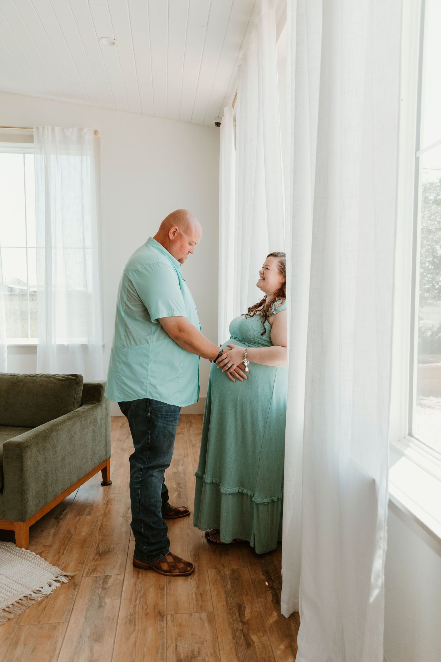 Couple in matching mint green outfits sharing tender moment in bright indoor setting.
