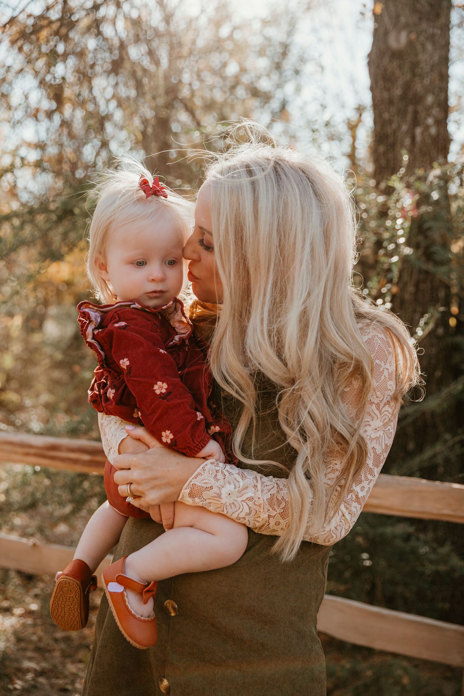 A tender outdoor portrait session captures intimate moments between parent and child in warm autumn lighting.
