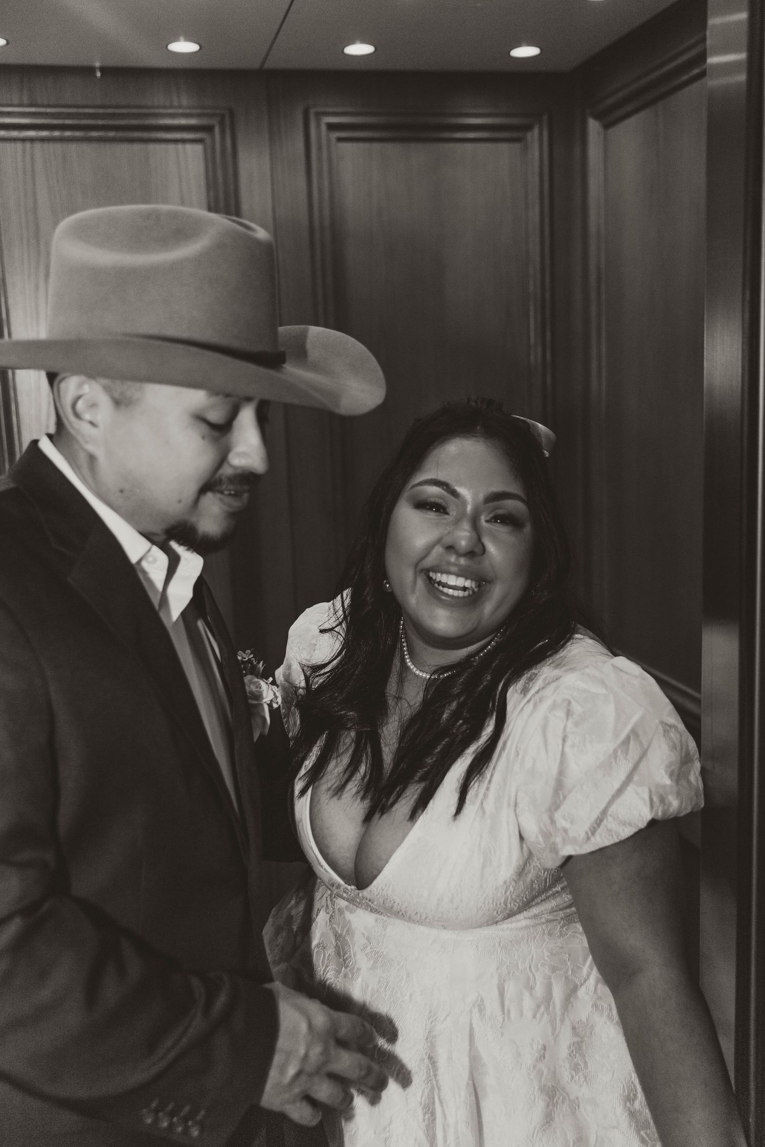 A couple sharing playful moments together in an elevator.