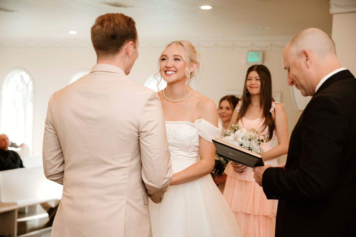 Wedding reception guests enjoying a lively dance celebration in an indoor venue.