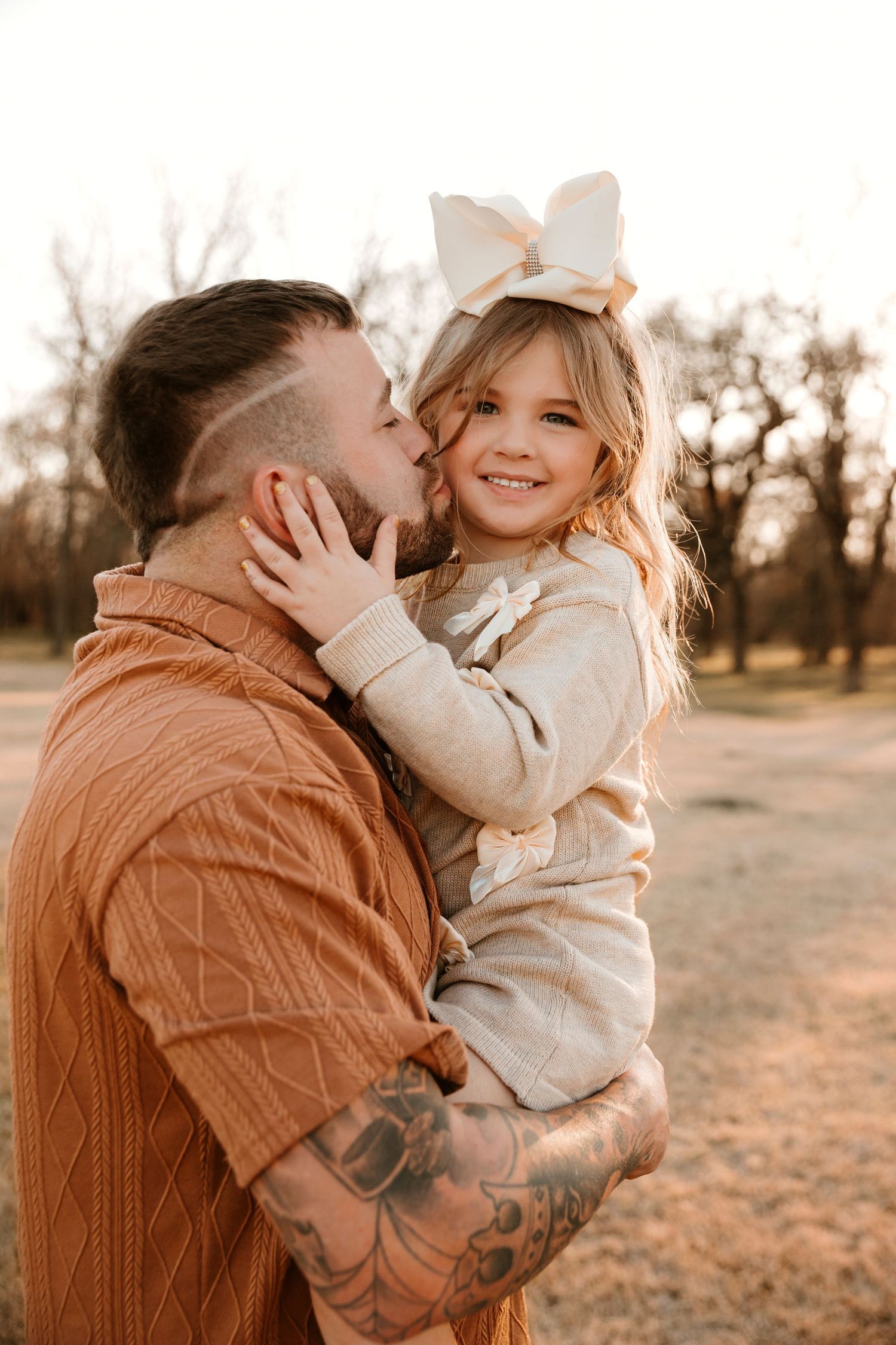 A tender moment captured between parent and child in warm sunset lighting outdoors.