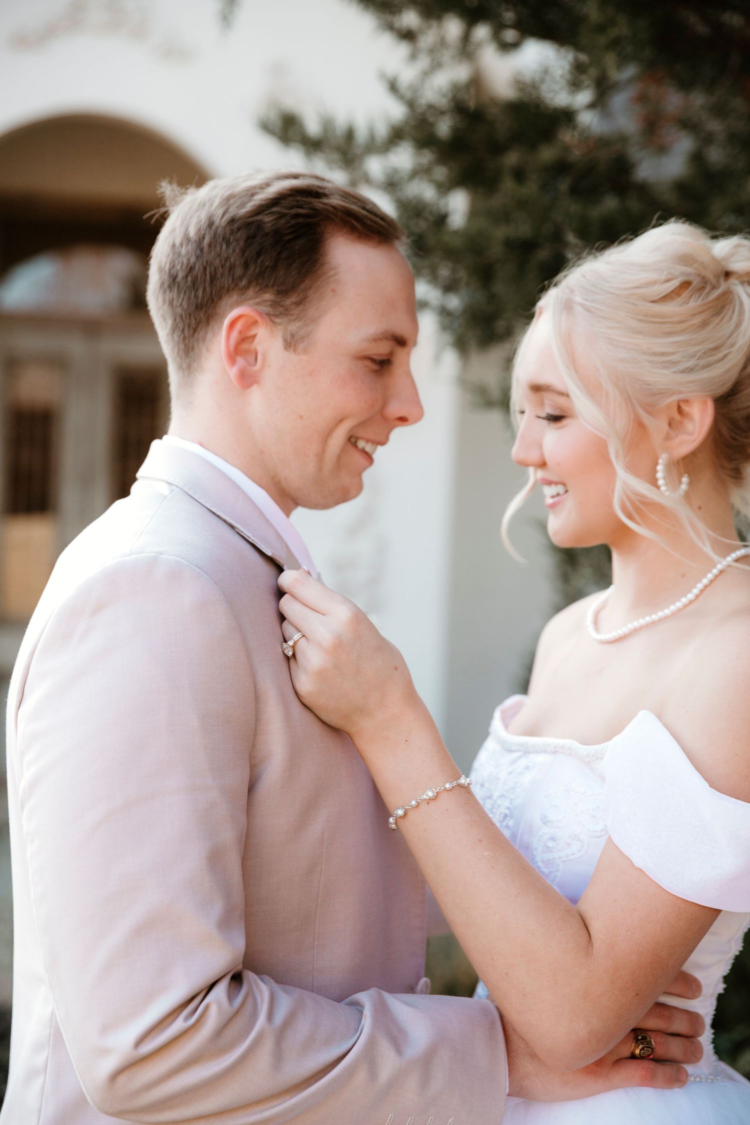 A romantic moment between newlyweds in formal wedding attire outdoors.