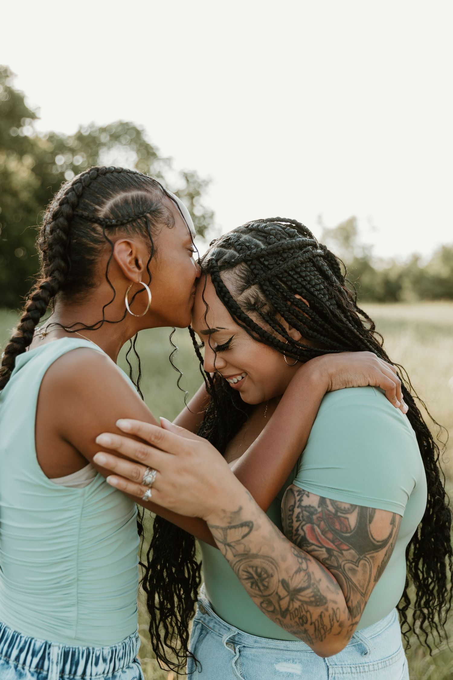 Intimate embrace shared in a meadow during golden hour photography session.