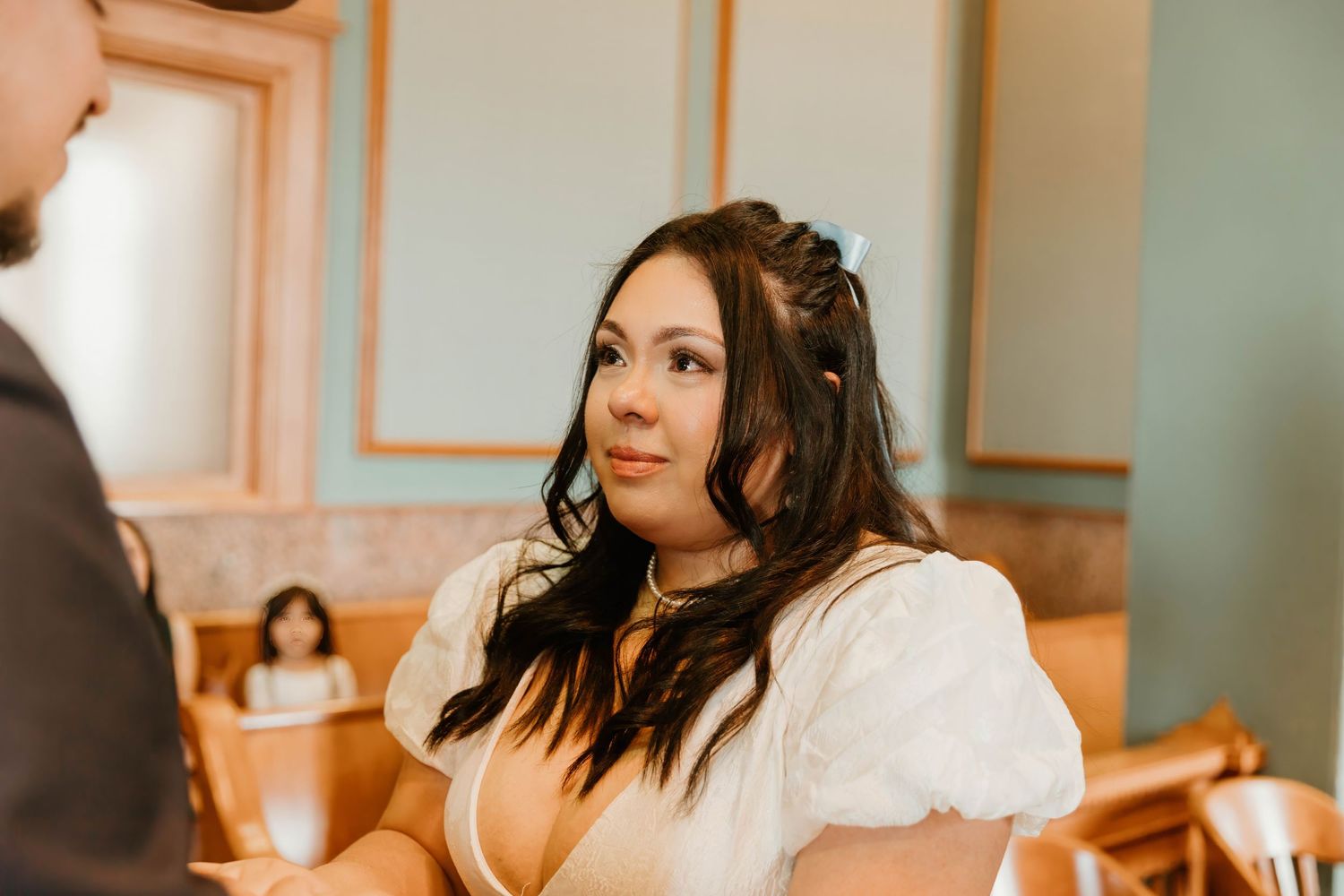 Bride in white dress smiles during intimate wedding ceremony.