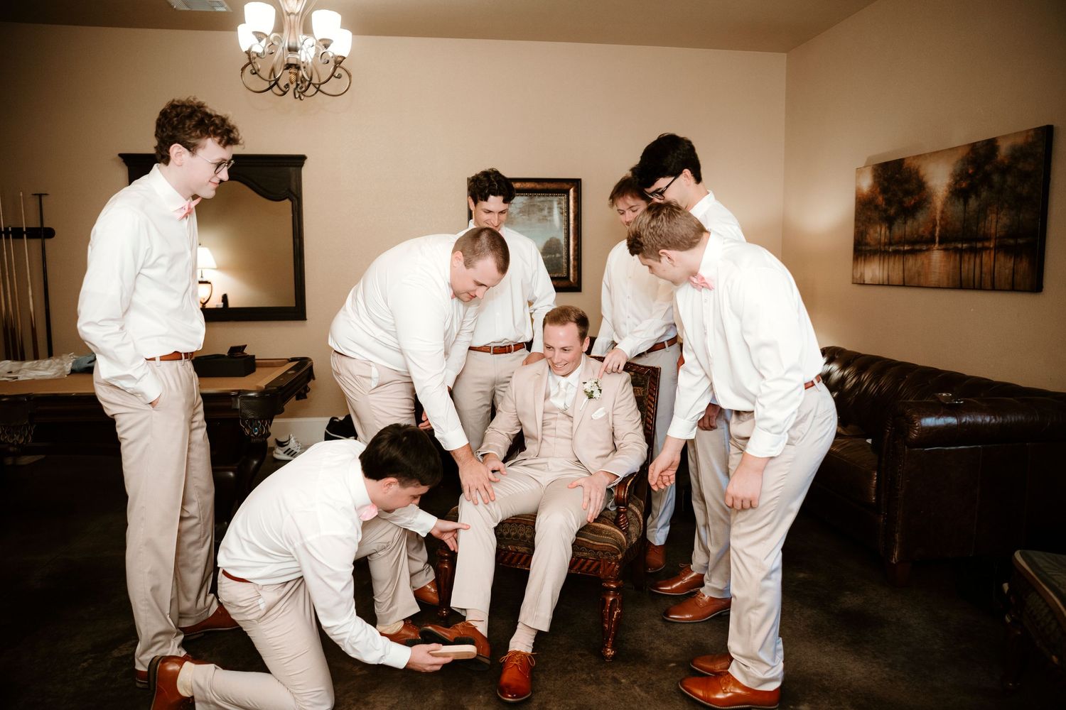 Wedding party in white attire dancing and celebrating together at a reception venue.