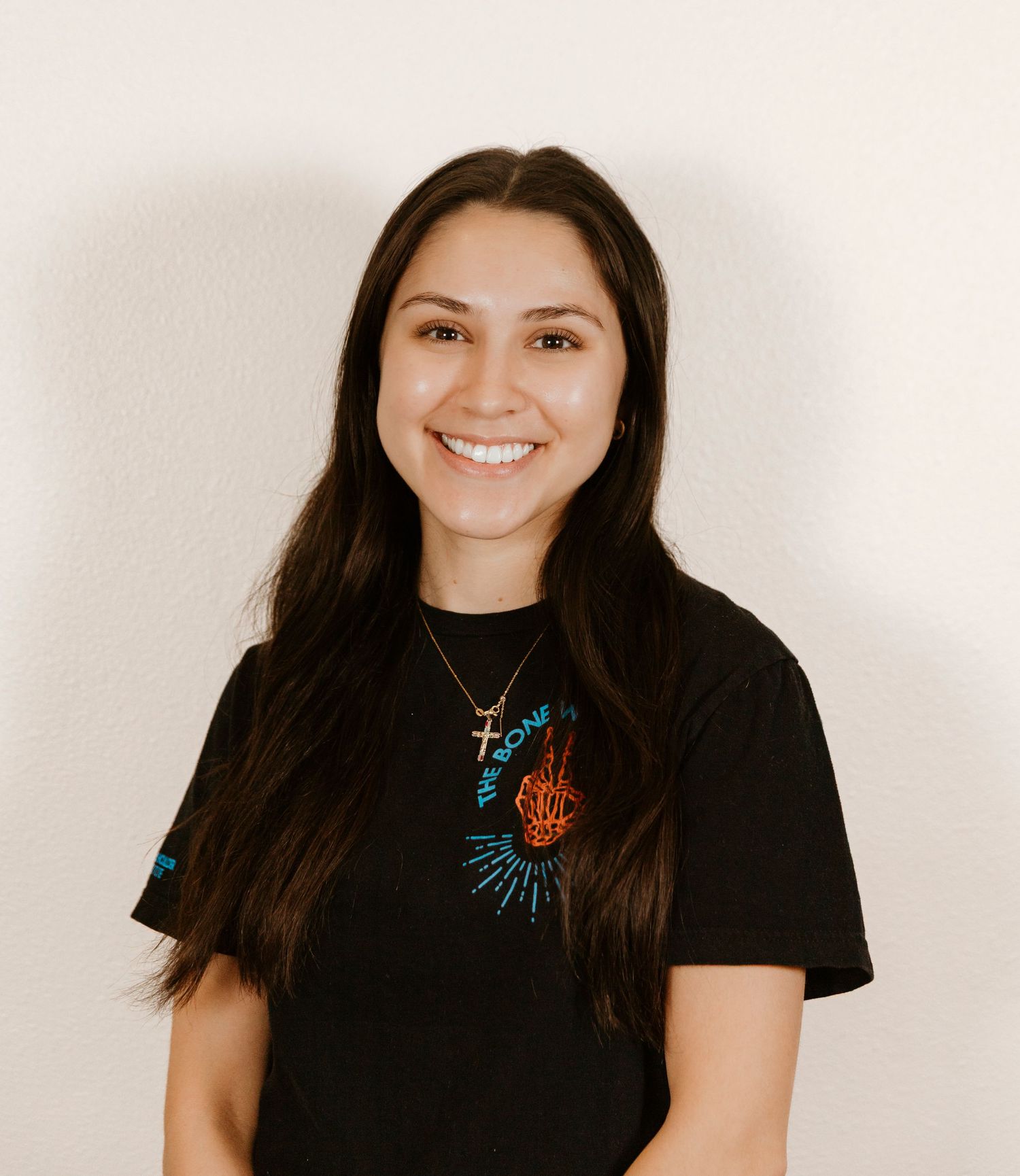 Professional headshot of person wearing black shirt and turquoise necklace.