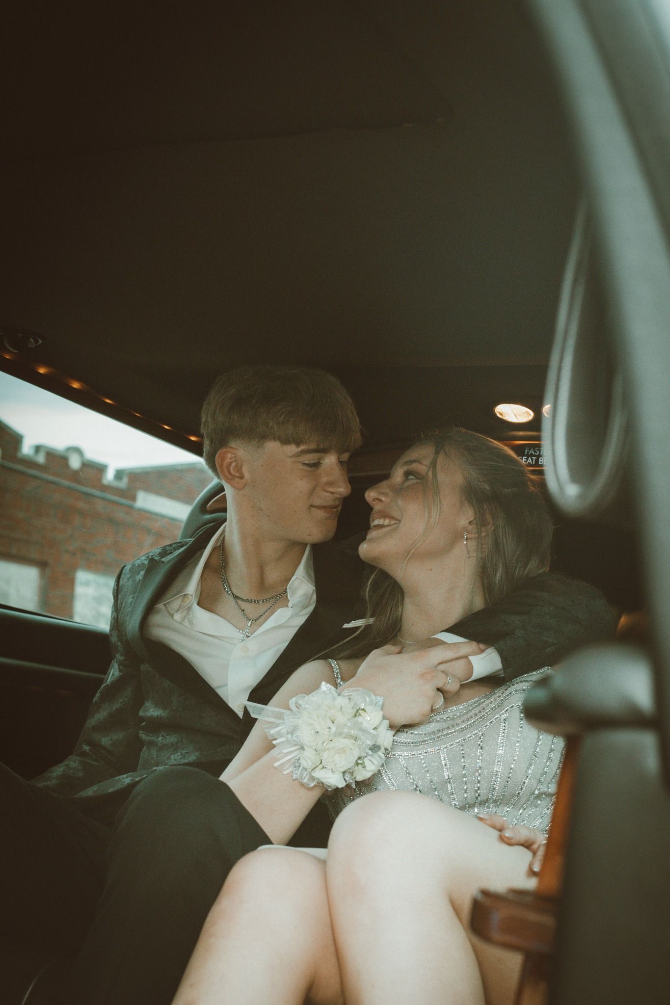 Romantic moment captured in car backseat with vintage mood lighting.