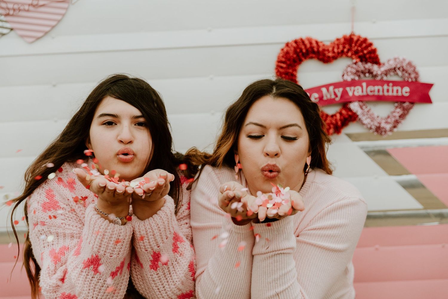 Fun Valentine's themed portrait session with playful poses and pink aesthetics.