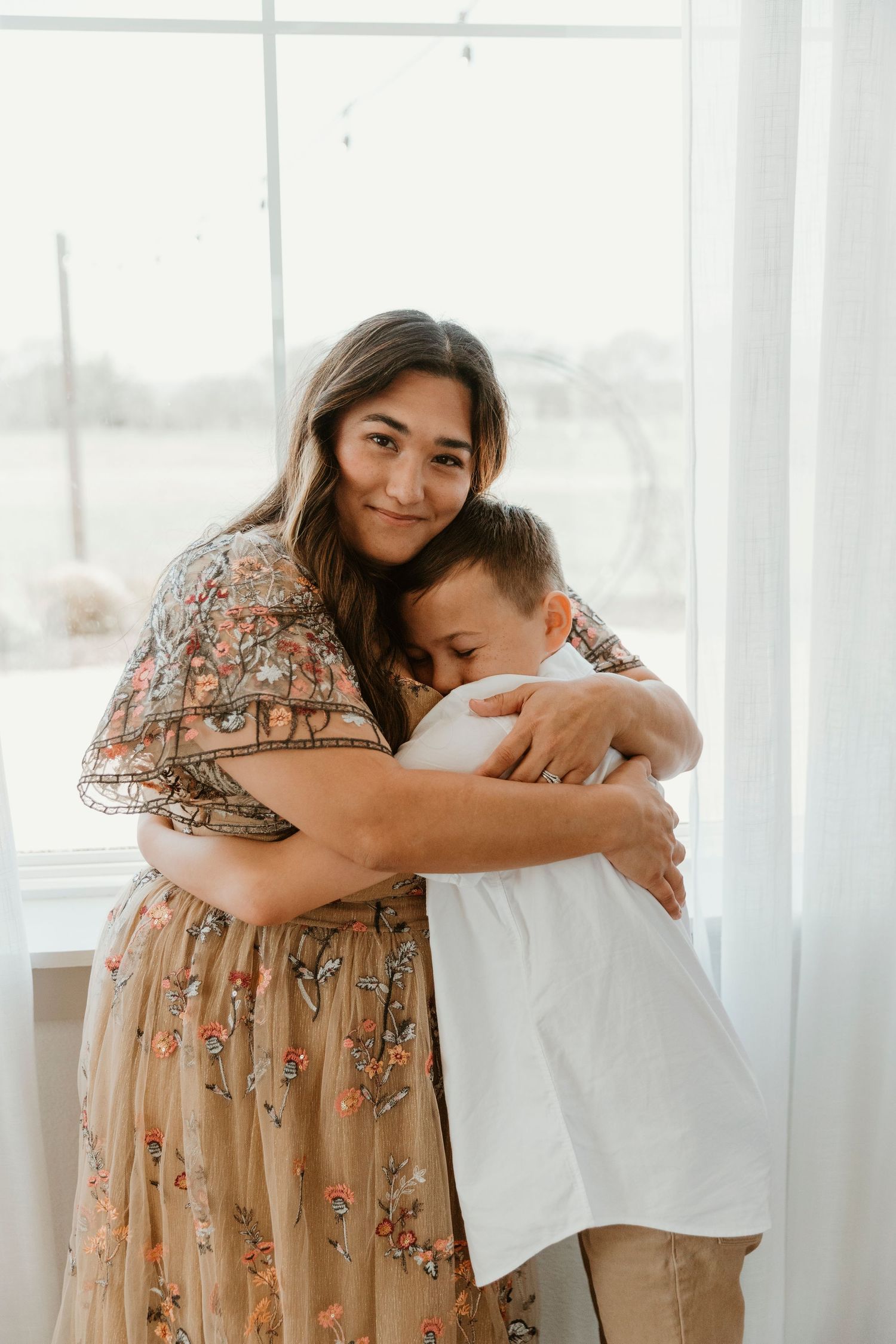 Heartwarming embrace between parent and child by bright window.