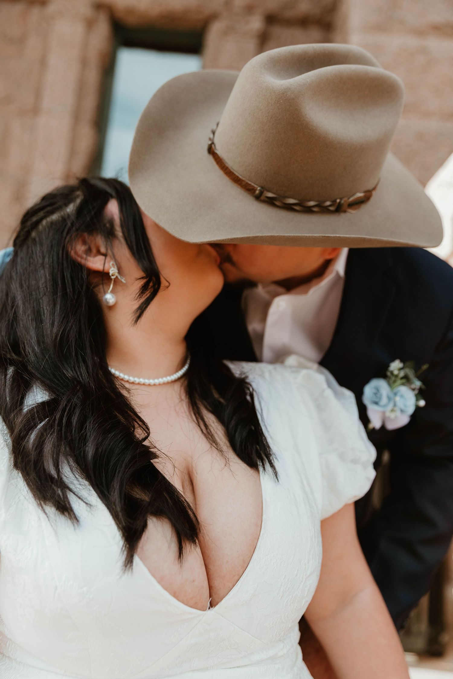 Close up of romantic moment between newlyweds near stone architecture.