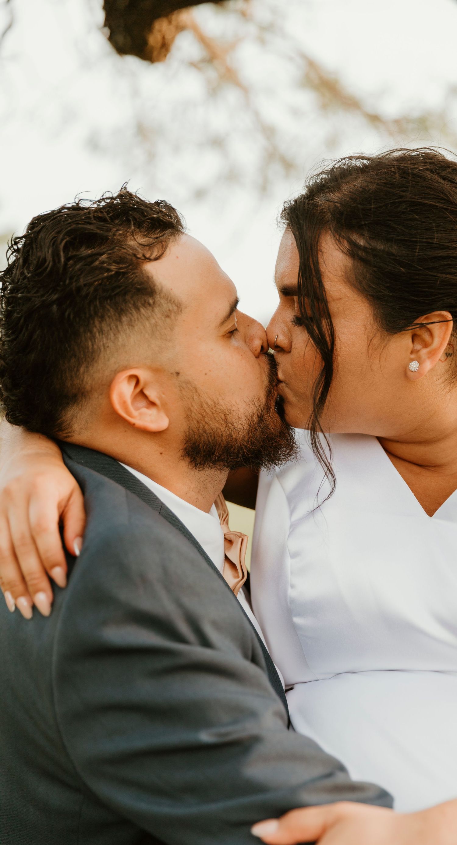 Intimate moment between newlyweds during outdoor wedding photoshoot.