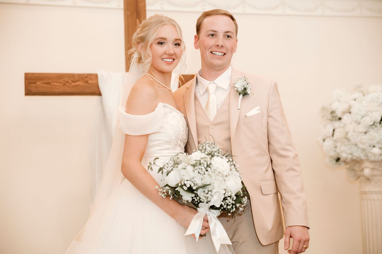 Elegant wedding celebration with guests dancing and mingling in a light-filled reception hall.