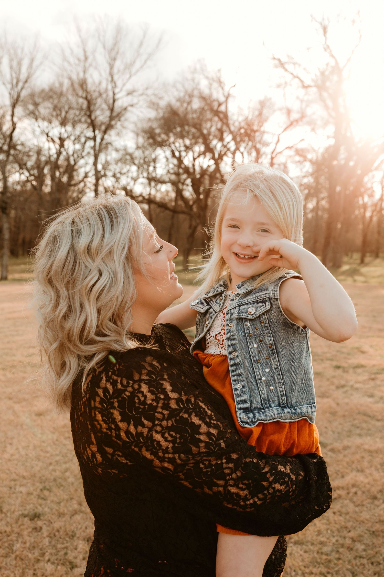 A heartwarming outdoor portrait at sunset showing shared laughter and tender moments in a natural setting.