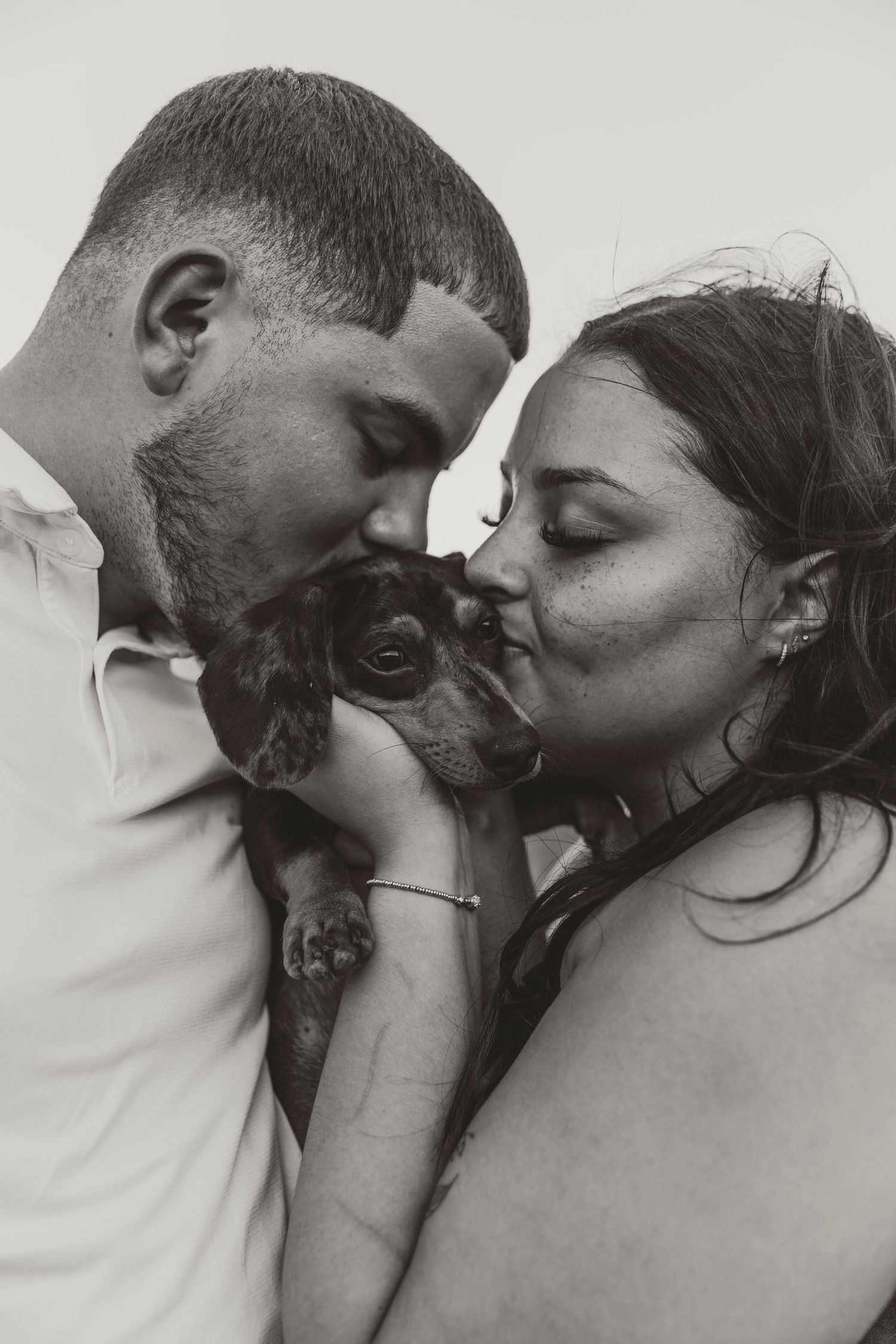 A series of black and white photos showing an intimate romantic moment between two people kissing.