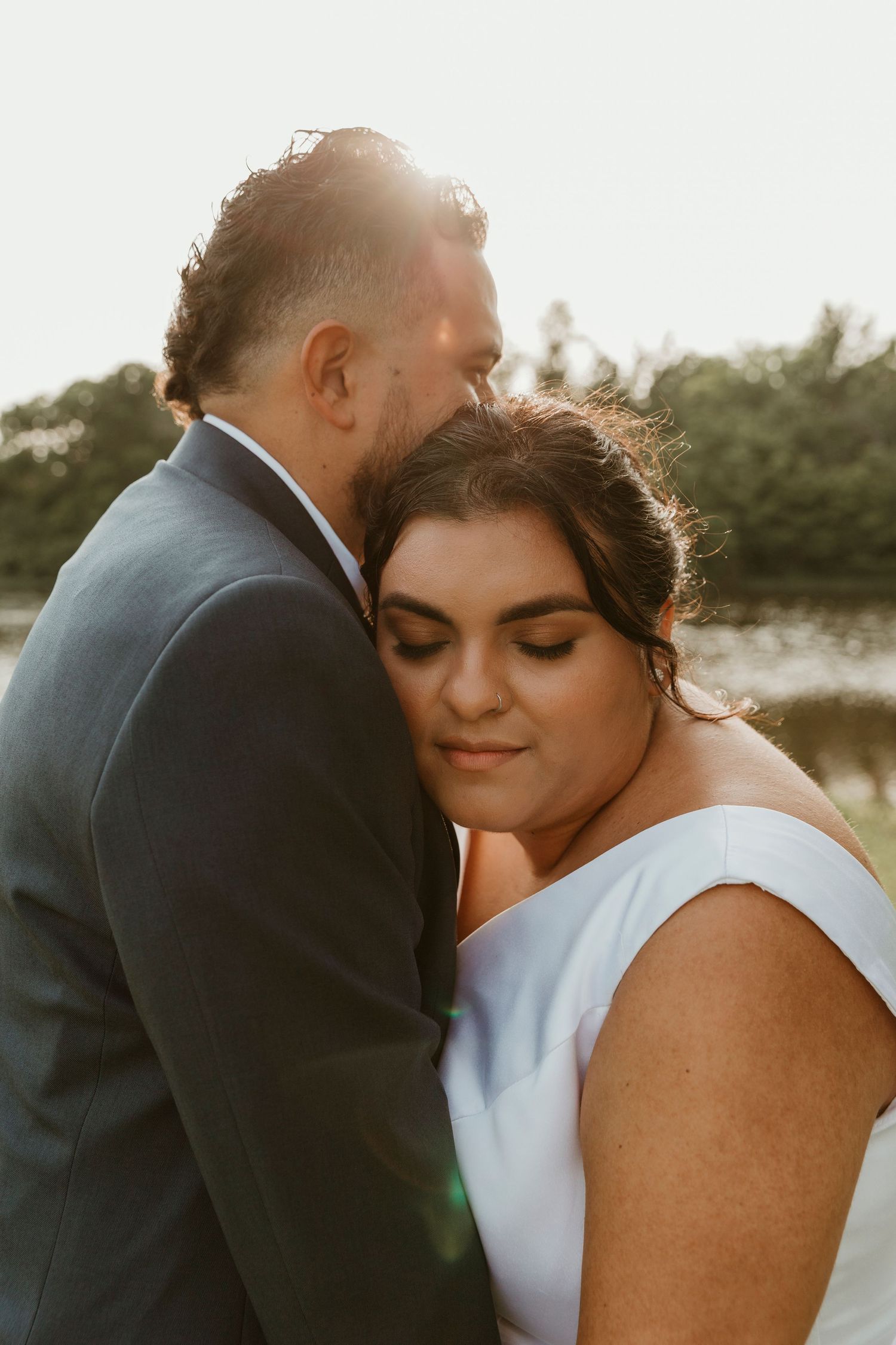 Intimate sunset portrait of newlyweds sharing a tender moment.