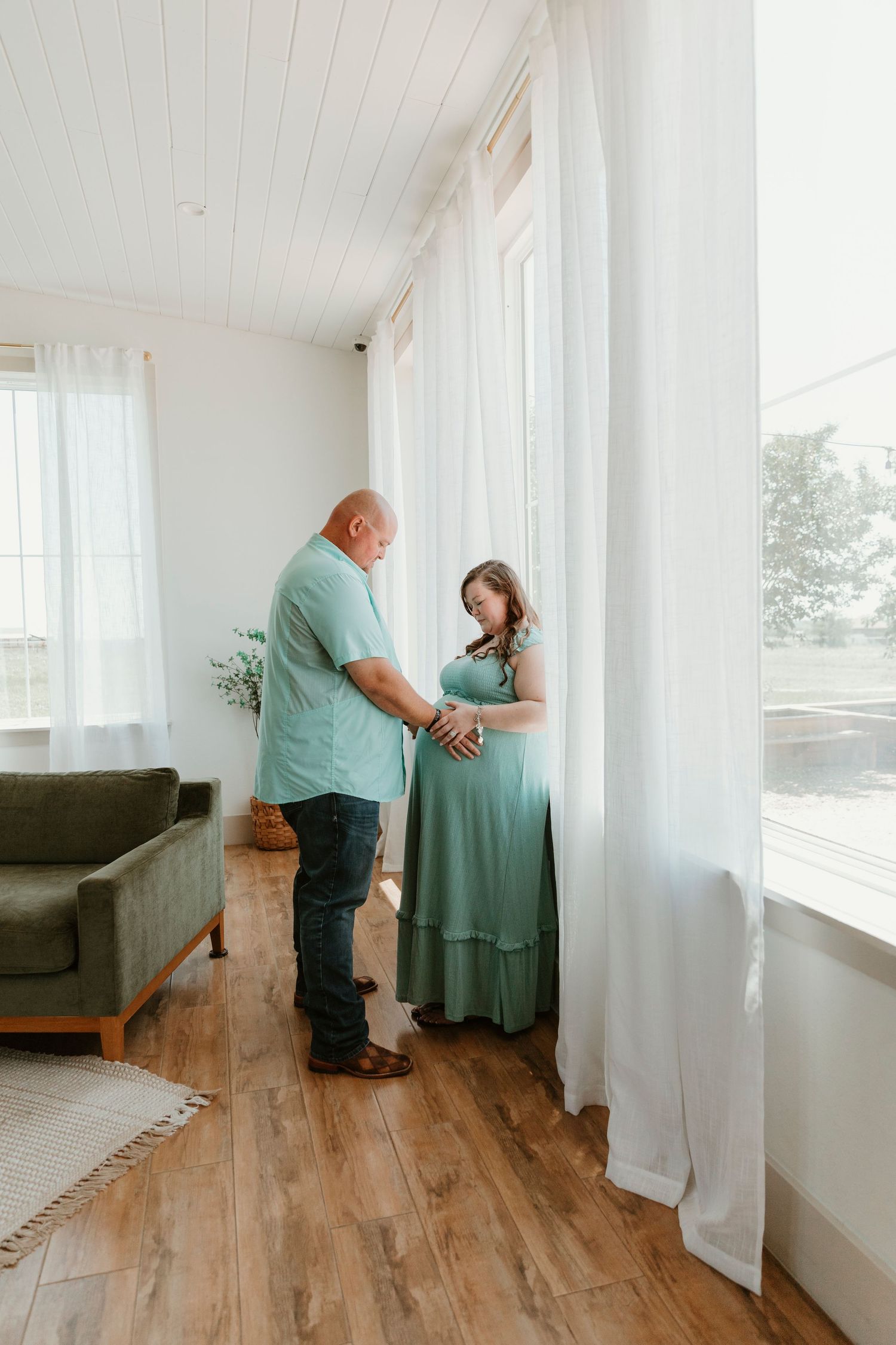 Romantic indoor photoshoot with couple in coordinated mint green attire.