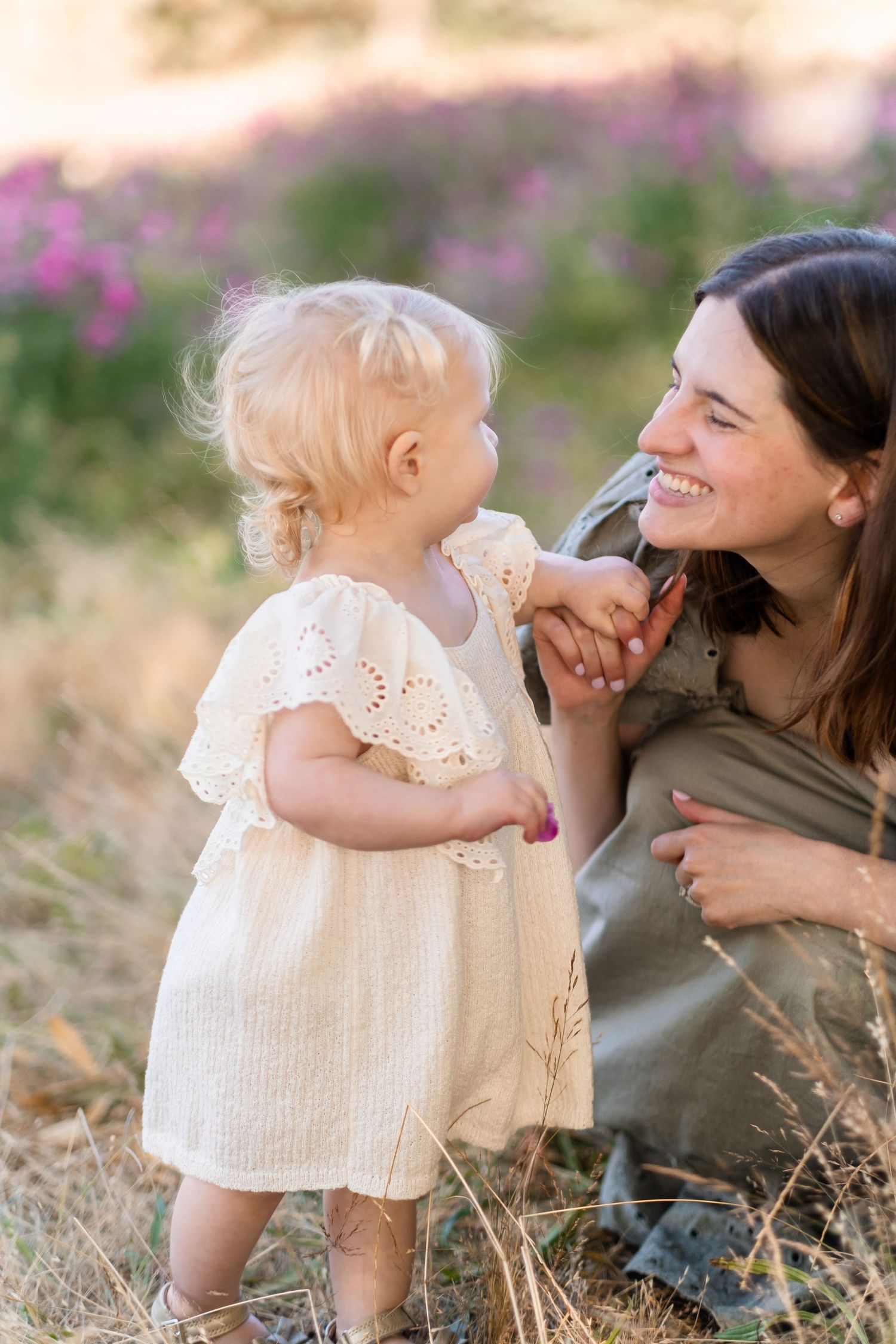 A heartwarming scene in a field of pink flowers shows a tender moment at sunset.