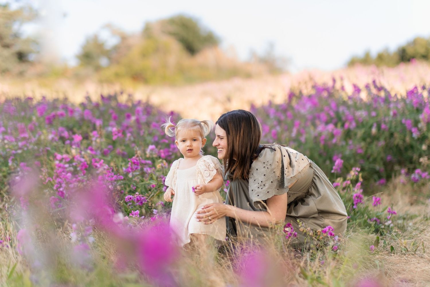 A tender moment shared between two people in a beautiful field of purple wildflowers during golden hour.