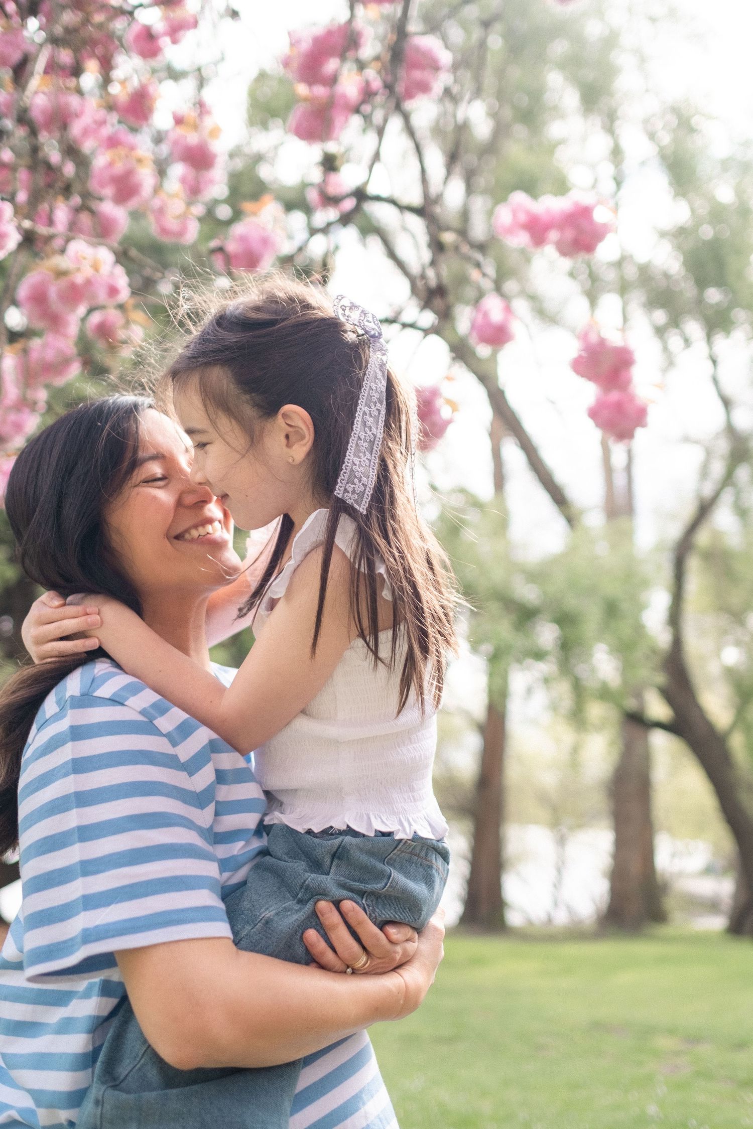 Tender embrace under blooming cherry blossoms in a spring garden setting.