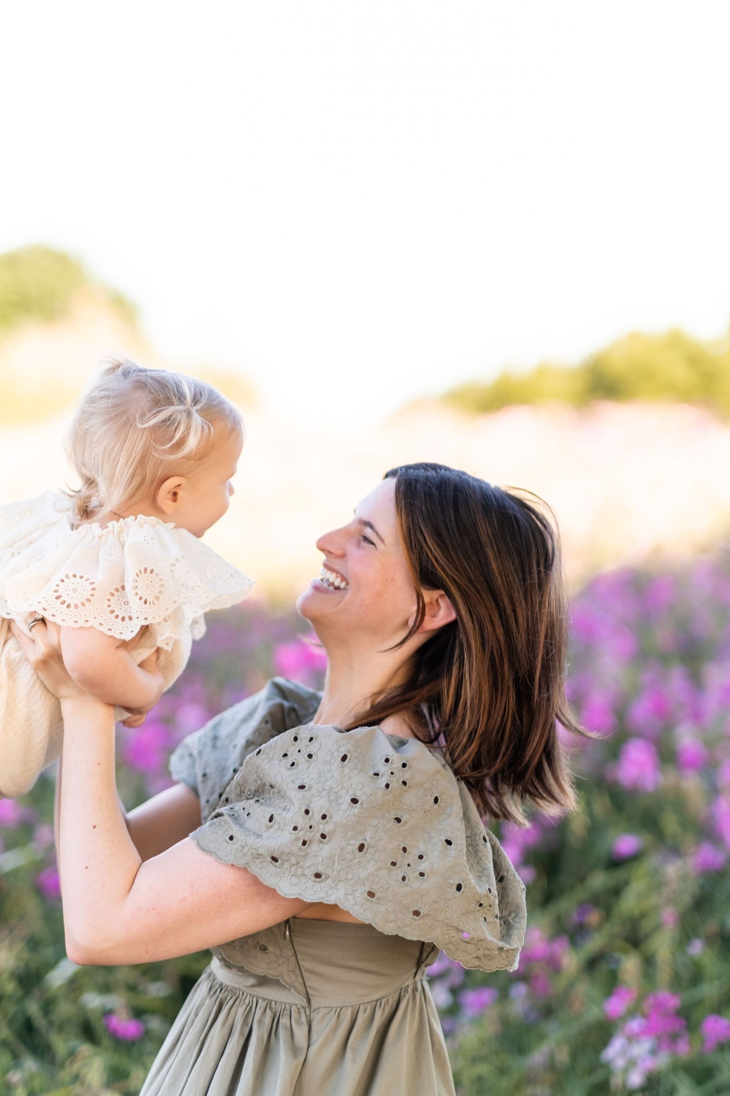 A joyful scene in a wildflower field with playful interaction amidst purple blooms at golden hour.