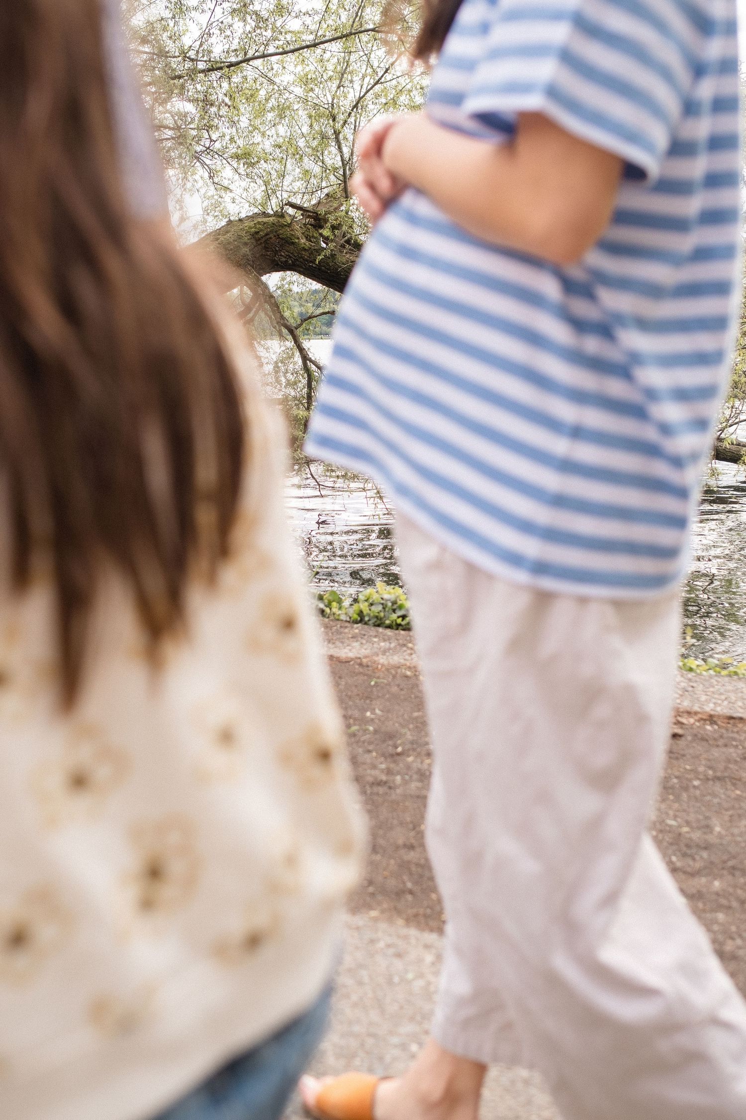 Children in casual clothing explore beneath blooming cherry blossom trees on a spring afternoon.