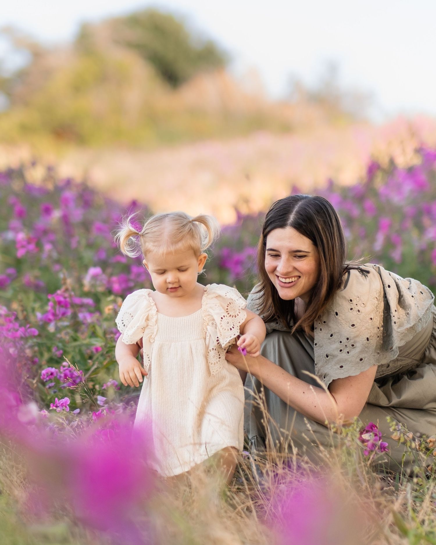 A heartwarming moment captured in a field of vibrant purple wildflowers on a sunny afternoon.