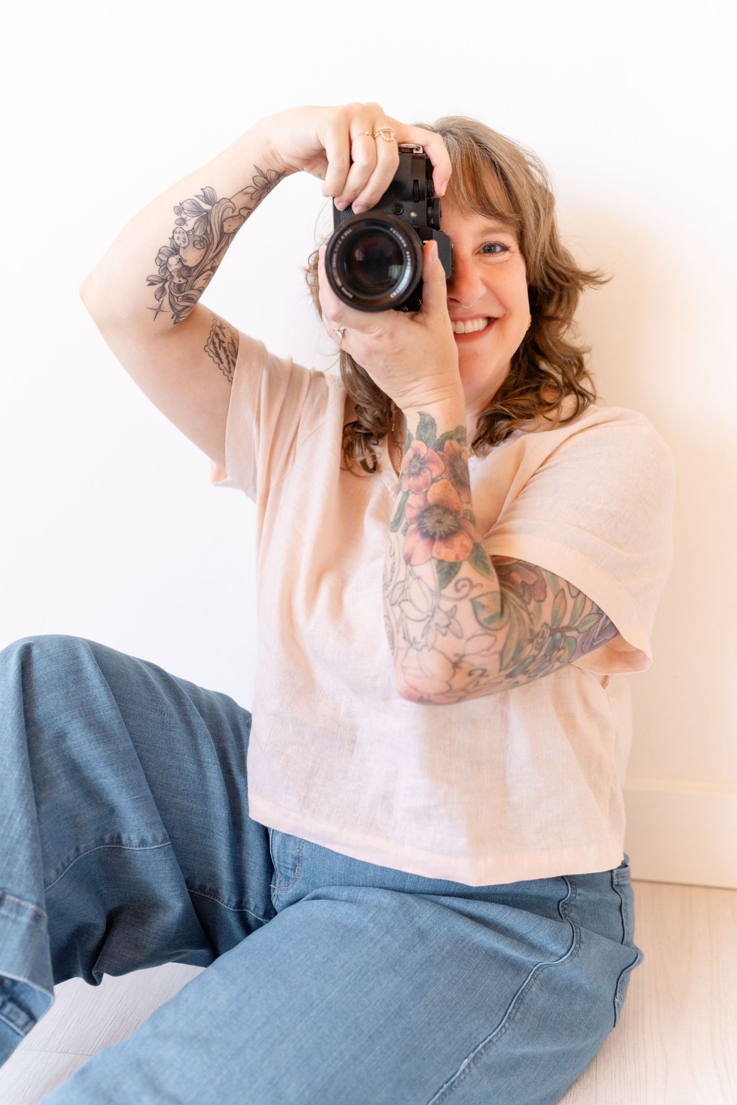 Multiple images of a person wearing a white shirt and blue jeans while holding a camera to take photographs.