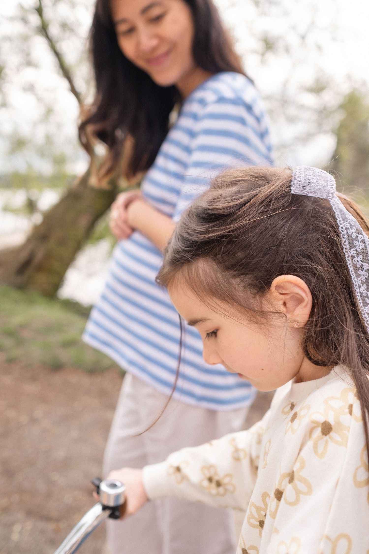 A tender springtime moment captured in soft lighting under blooming trees.