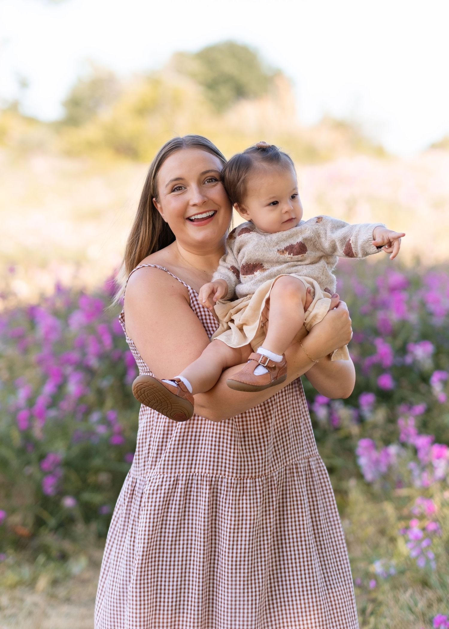 A joyful moment captured in a field of purple wildflowers on a sunny afternoon.