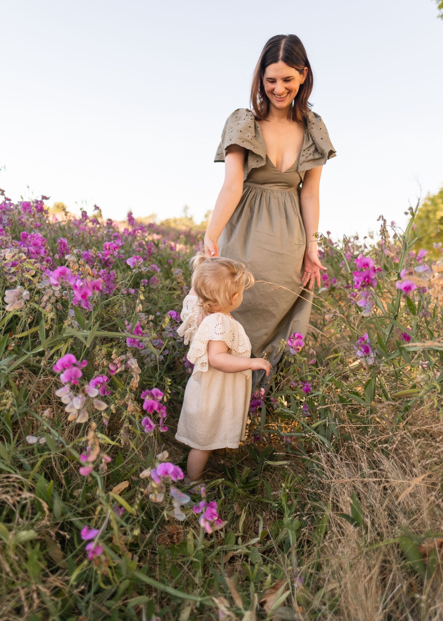 A tender moment captured in a field of purple flowers as an adult and child share time together.