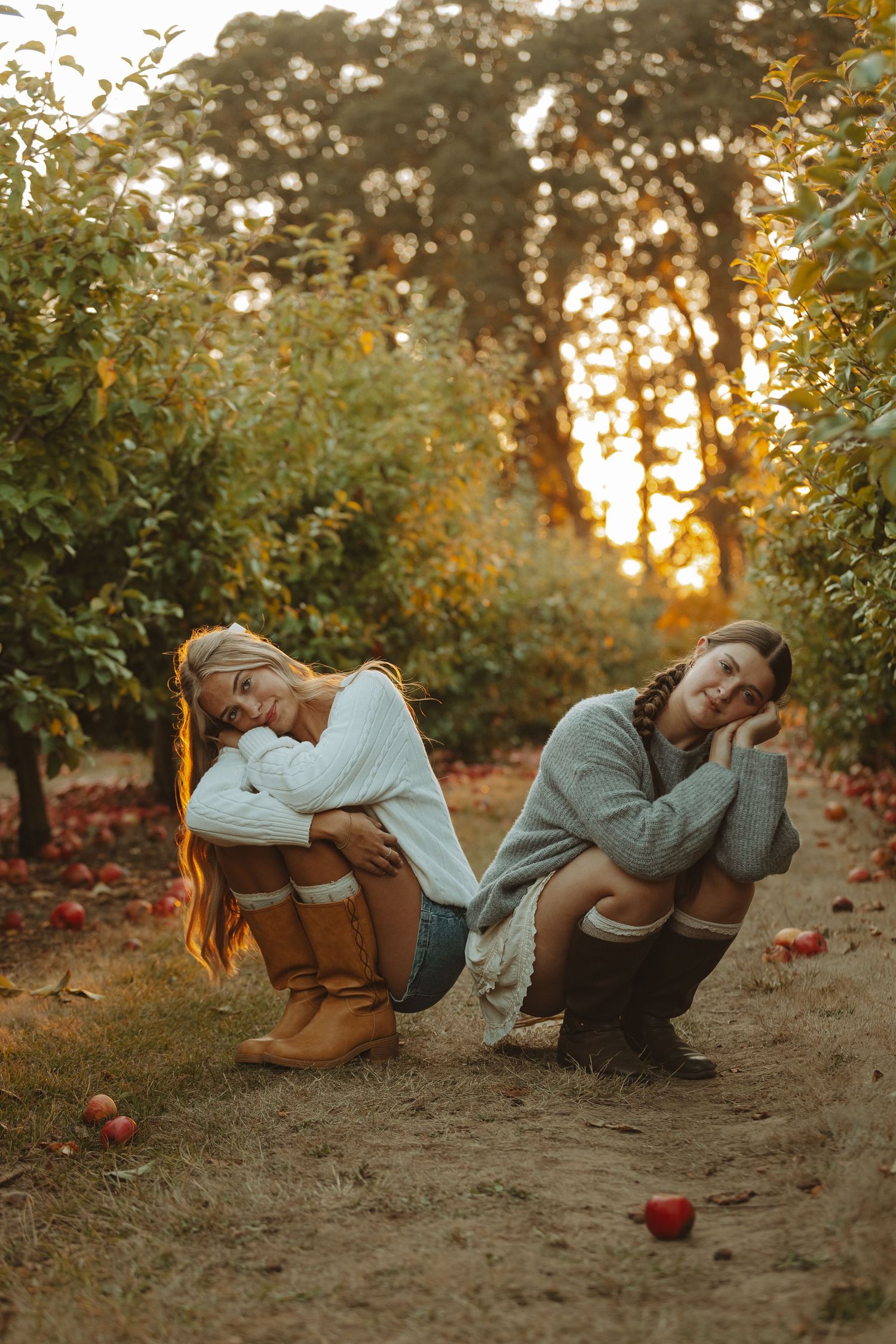 Playful poses captured in an apple orchard at golden hour.